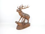 statue of a stag on a log with antlers on it