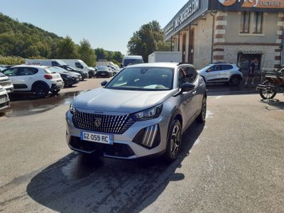 une voiture argentée garée devant un bâtiment dans un parking