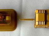 a yellow toy car and a yellow toy car on a white surface