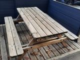une table de pique-nique posée sur une plate-forme en bois dans un parking