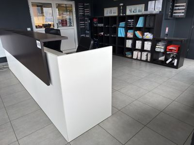 un comptoir d'accueil blanc avec un plan de travail noir et blanc