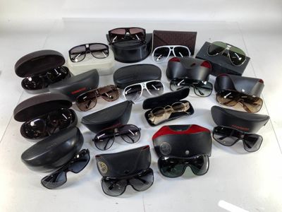 many pairs of sunglasses sitting on a white surface