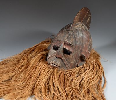 un masque marron avec de longs cheveux sur un fond blanc