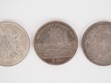 three different types of coins are shown on a white surface
