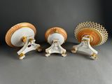 three white and gold vases sitting on top of a table