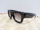 une paire de lunettes de soleil noires posée sur un panier en osier