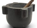 un mortier contenant un bâton en bois, sur fond blanc