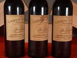 three bottles of wine sitting on a table next to a wooden box