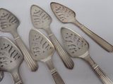 five silver spoons and a spoon with a design on them
