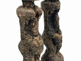 sculpture of two stone figures on a wooden base on a white background