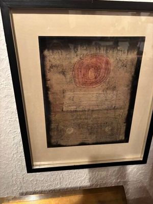 tableau représentant un cercle rouge dans un cadre noir, accroché au mur
