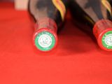 two bottles of wine sitting on a red cloth