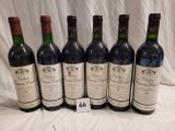 six bottles of red wine are lined up on a table