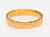 a close up of a gold ring on a white surface