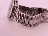 a silver watch that is sitting on a white surface