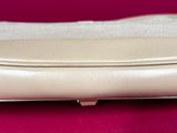 an image of a white purse sitting on top of a pink surface