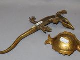 a small lizard that is sitting on top of a gold plate