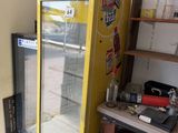 a refrigerator in the corner of a room with a lot of clutter on it