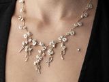 Cette femme porte un collier composé de perles et d'or.