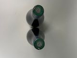 two bottles of beer sitting on a white surface