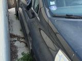 a black car that is parked next to a wall