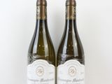 deux bouteilles de vin blanc posées l'une à côté de l'autre sur une surface blanche