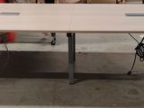 une table sur laquelle est posé un ordinateur portable, dans une pièce