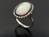 une bague en oplite blanche et diamant sur un fond noir