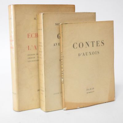 three books sitting on top of each other on a white surface
