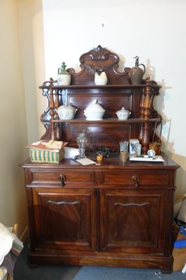 une grande armoire en bois sur laquelle sont posés de nombreux objets