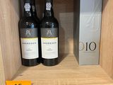 des bouteilles de vin sur une étagère dans un magasin, avec une étiquette de prix