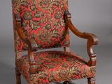 an old chair with a red and green floral upholstered seat