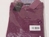 purple polo shirt in plastic bag on white background with price tag
