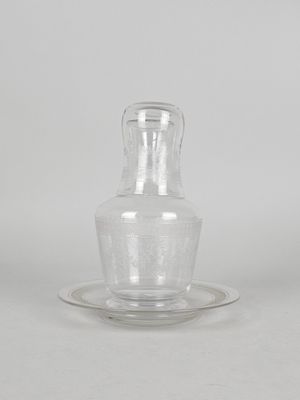 a clear glass bottle with a saucer on a saucer
