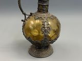 un vase ancien en argent et or, muni d'une anse et posé sur un socle
