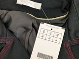 the label on the back of a black suit with red stitching