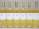 six bouteilles de vin blanc sont alignées