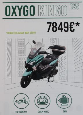 une affiche faisant la promotion d'un scooter garé devant un immeuble