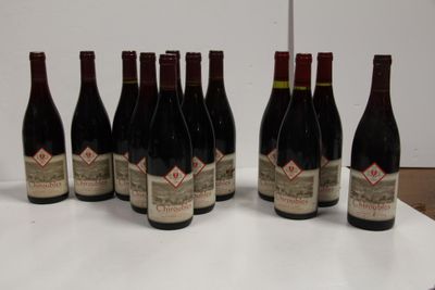 six bottles of red wine are lined up on a table