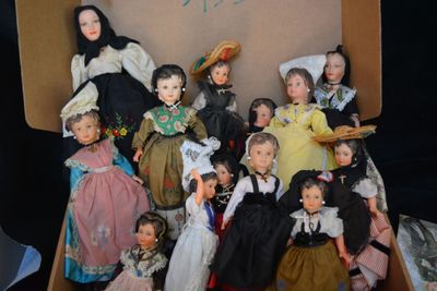 many dolls in a box that are sitting on a table
