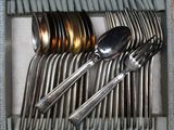 a lot of silver spoons and spoons in a box