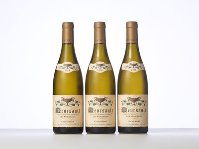 trois bouteilles de vin posées l'une à côté de l'autre sur une table