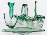 trois vases en verre vert posés sur un plateau en verre