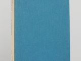 a blue book sitting on top of a table next to a white wall