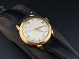 an image of a gold watch on a black leather strap