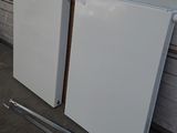 two white refrigerators sitting next to each other on the floor