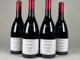 trois bouteilles de vin rouge sont alignées sur une table