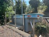 une photo d'une station de traitement des eaux au milieu des bois
