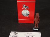 une petite boîte rouge avec une petite figurine à côté