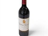 la bouteille de vin rouge est posée sur une surface blanche